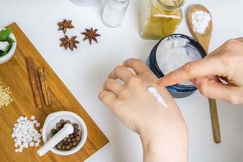 Young woman is applying homemade cream on her skin. A lot of ing
